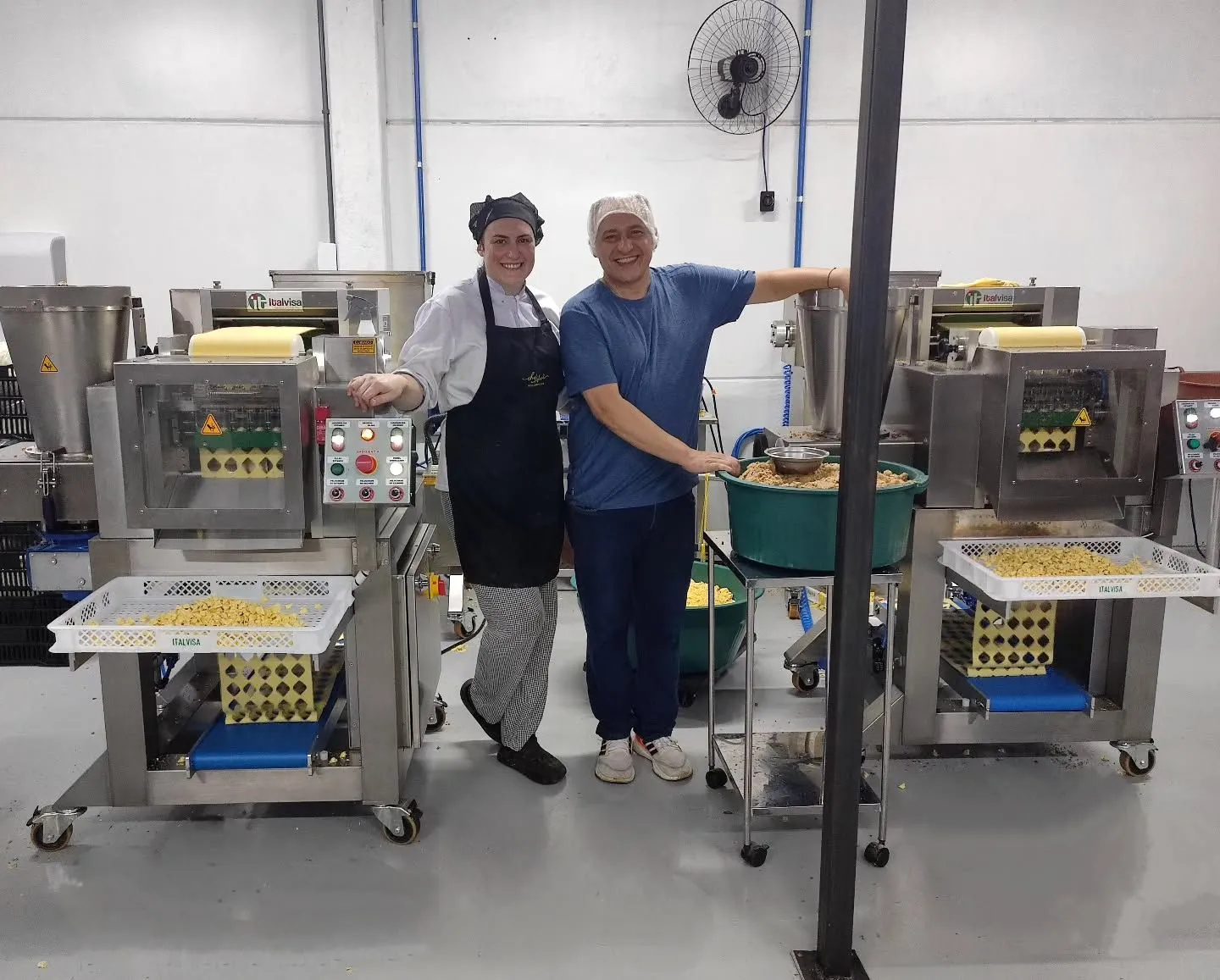 Duas pessoas da equipe Zaccaron sorrindo na área de produção das massas